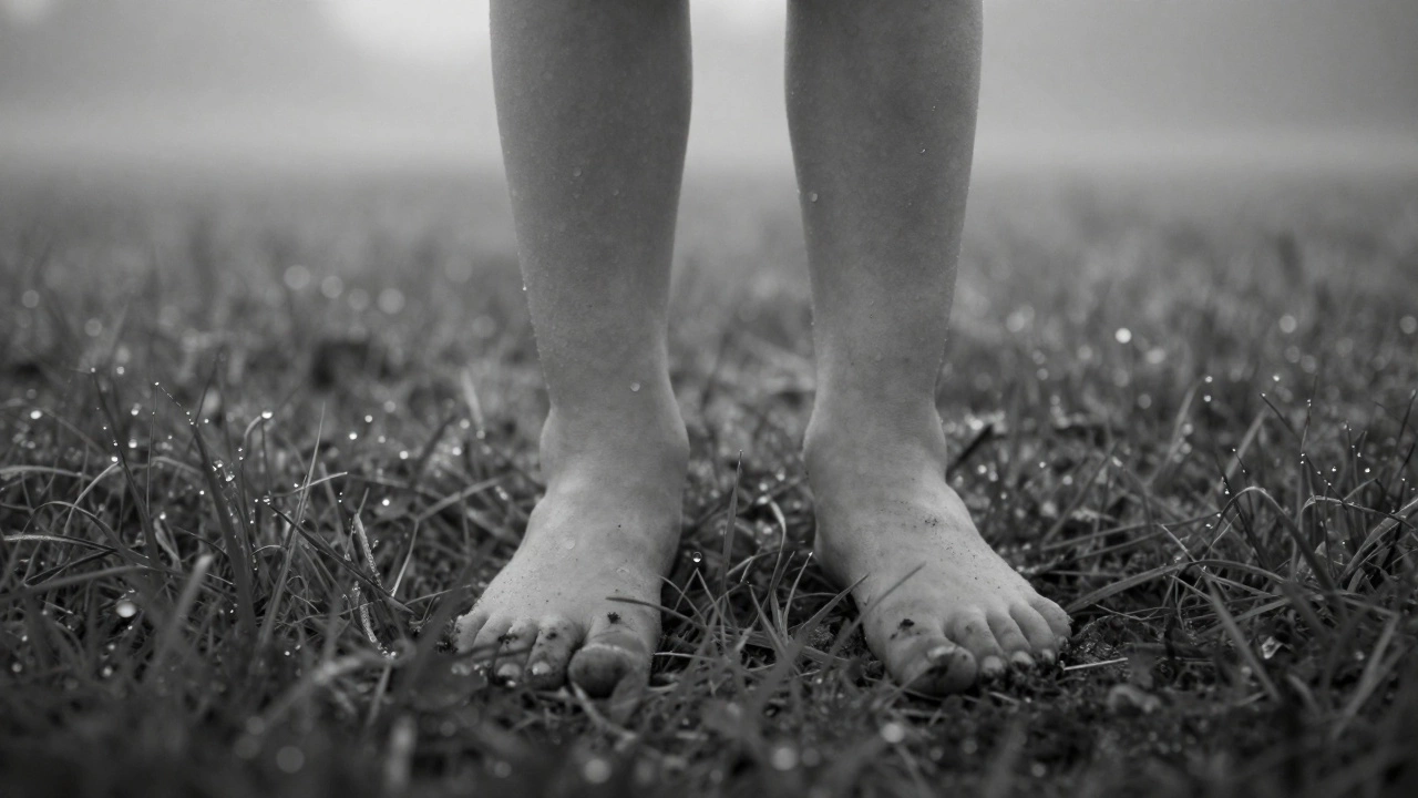 A child's bare feet in a dewy field at dawn, dirt on their toes, surrounded by mist and natural light.